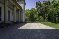 the walkway is empty in front of the house and trees in the background on a sunny day