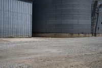 a street view of two round silos outside a storage building with a sign on one side
