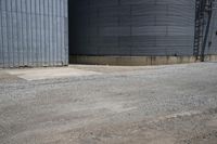 a street view of two round silos outside a storage building with a sign on one side