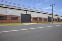 a motorcycle is parked outside of a large industrial building on the side of a road