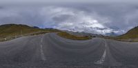 a 360 - view image of the road with the mountains in the background is shown