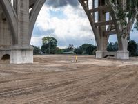 the construction work is under an overpass bridge on a cloudy day in the park