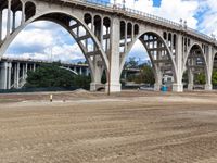 large structure near the roadway with a construction site in foreground area and buildings next to the bridge