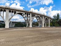 large structure near the roadway with a construction site in foreground area and buildings next to the bridge