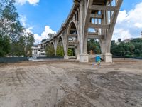 a bridge under construction and dirt with a blue fire hydrant in front of it