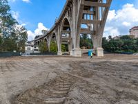 a bridge under construction and dirt with a blue fire hydrant in front of it