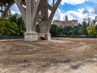 the dirt is brown in the middle of an area with a bridge and hotel in the background