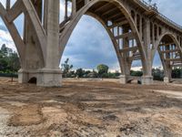 this is a view of a bridge construction with the road crossing in the background from underneath it