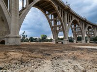 this is a view of a bridge construction with the road crossing in the background from underneath it