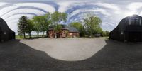 the 360 - view of a building, in front of other barns and buildings in the park