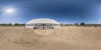 360 - zooming shot of a barn in the middle of nowhere with barbed wire hanging from it