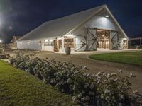 a horse stable that is made out of white wood and metal with the windows painted to resemble barn