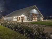 a horse stable that is made out of white wood and metal with the windows painted to resemble barn