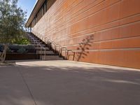 the shadow of a motorcycle is cast on a wall next to steps and trees in front