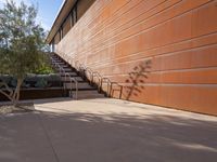 the shadow of a motorcycle is cast on a wall next to steps and trees in front