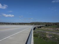 an interstate highway with two lanes going over an obstacle level bridge above the other side