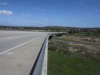 an interstate highway with two lanes going over an obstacle level bridge above the other side