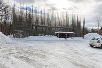 a car is parked at a rural parking lot on a snowy day and it has fallen over