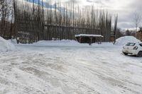 a car is parked at a rural parking lot on a snowy day and it has fallen over