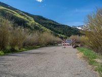 an open gate sits behind a warning sign on the side of the road that's blocked off