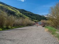 an open gate sits behind a warning sign on the side of the road that's blocked off