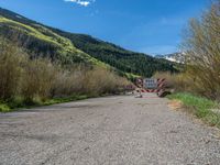 an open gate sits behind a warning sign on the side of the road that's blocked off