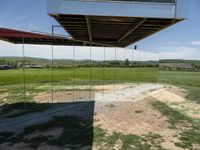 a couple of mirrors that are sitting on the ground in grass and dirt area of a house