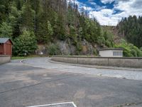 concrete walkway with trees and fenced in area on opposite sides of the road and one side of the road