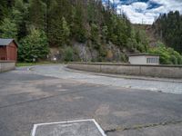 concrete walkway with trees and fenced in area on opposite sides of the road and one side of the road