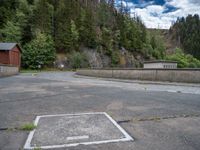 concrete walkway with trees and fenced in area on opposite sides of the road and one side of the road