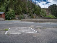 concrete walkway with trees and fenced in area on opposite sides of the road and one side of the road