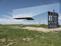 an upside down reflection shows the inside of it's enclosure and in the grass