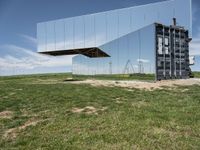 an upside down reflection shows the inside of it's enclosure and in the grass