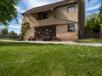 an old house next to a sidewalk in a country setting with a fence around it