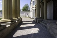 a hallway in an historic building next to pillars with columns in the middle and a stone bench on the ground below