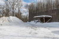 the house is made of wood, covered with snow and surrounded by piles of dirt