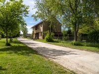 a stone paved road going up to an old stone house in the countryside of rural town