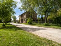 a stone paved road going up to an old stone house in the countryside of rural town