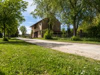 a stone paved road going up to an old stone house in the countryside of rural town