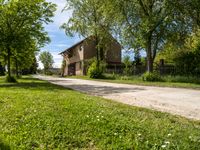 a stone paved road going up to an old stone house in the countryside of rural town