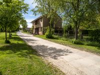 a stone paved road going up to an old stone house in the countryside of rural town