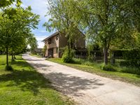 a stone paved road going up to an old stone house in the countryside of rural town