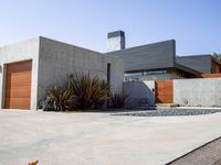 a gray concrete building with stairs and door at the top of the floor next to it is steps leading down to the doorway