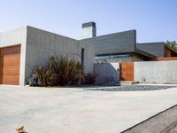 a gray concrete building with stairs and door at the top of the floor next to it is steps leading down to the doorway