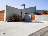 a gray concrete building with stairs and door at the top of the floor next to it is steps leading down to the doorway