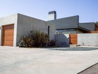 a gray concrete building with stairs and door at the top of the floor next to it is steps leading down to the doorway