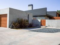 a gray concrete building with stairs and door at the top of the floor next to it is steps leading down to the doorway