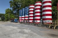 a red white and blue factory or grain silo has many different colors on them