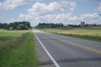 a highway with a sign on the side of it that reads to a green field, along with an empty road