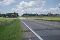 a highway with a sign on the side of it that reads to a green field, along with an empty road